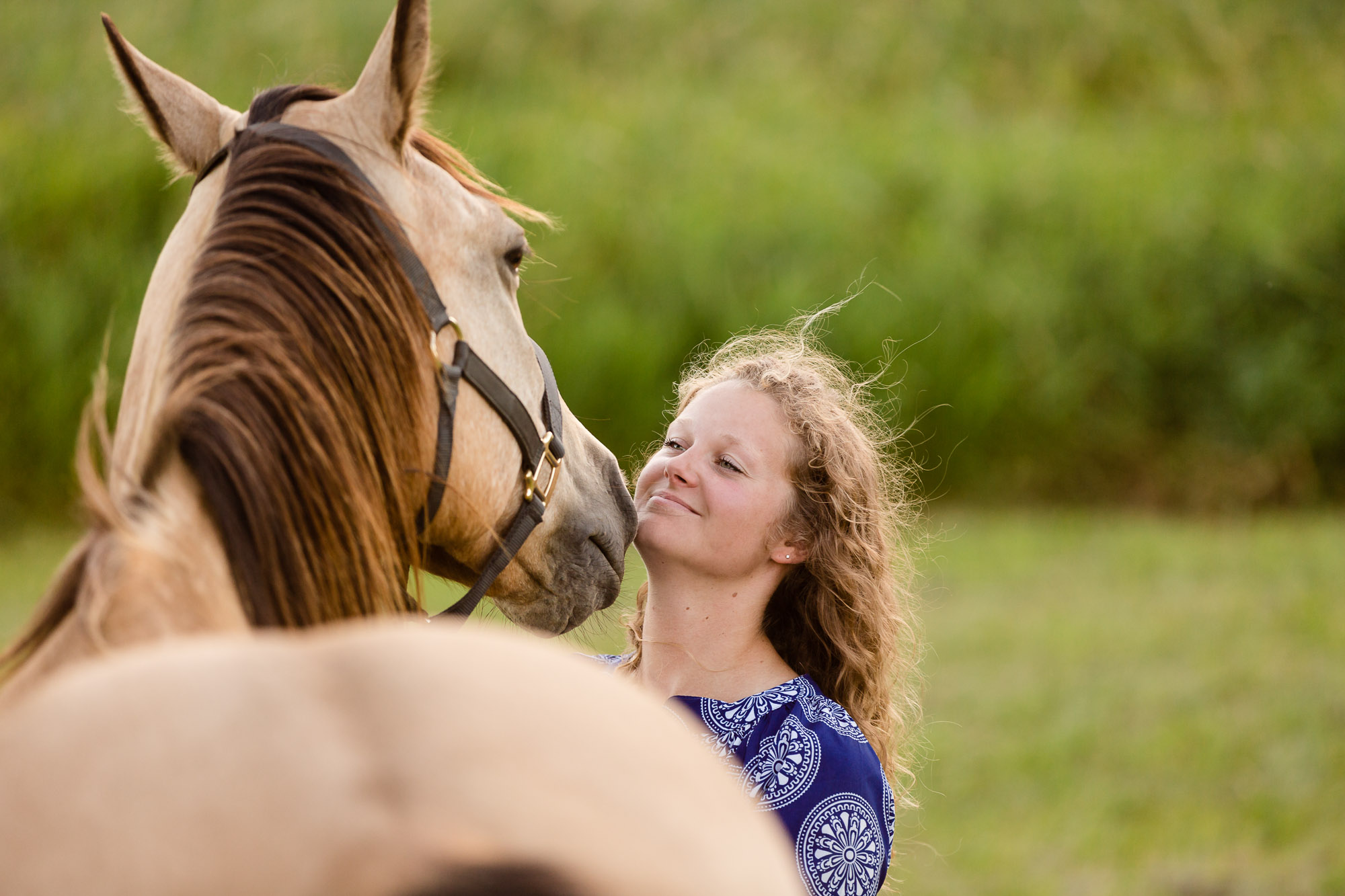 blonde woman with buckskin horse in a field in Minnesota
