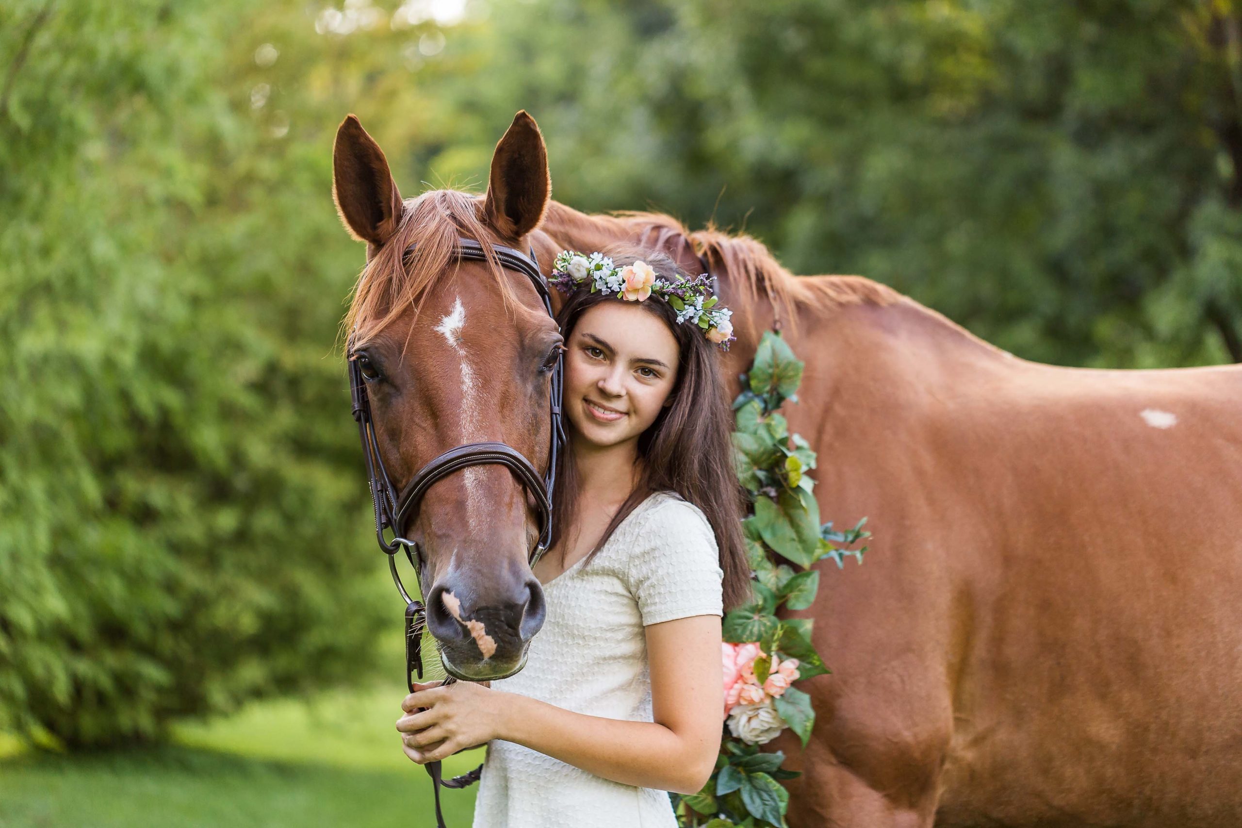 girl with flowers in hair with chestnut horse