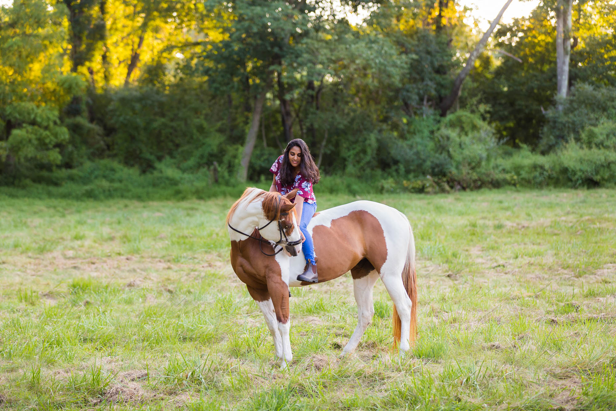 young woman on a paint mare horse in a field in New Jersey