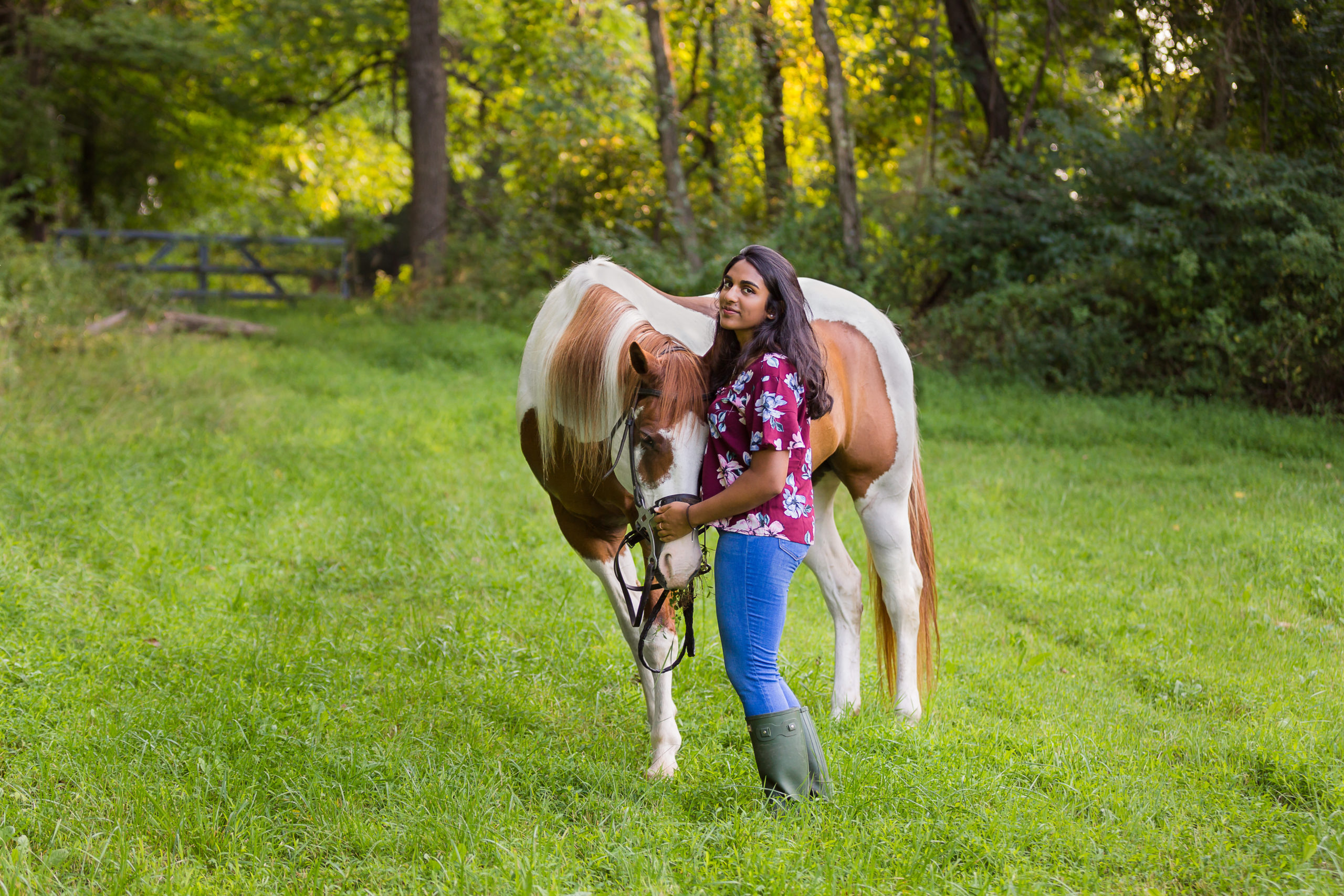 girl with paint horse in grassy field