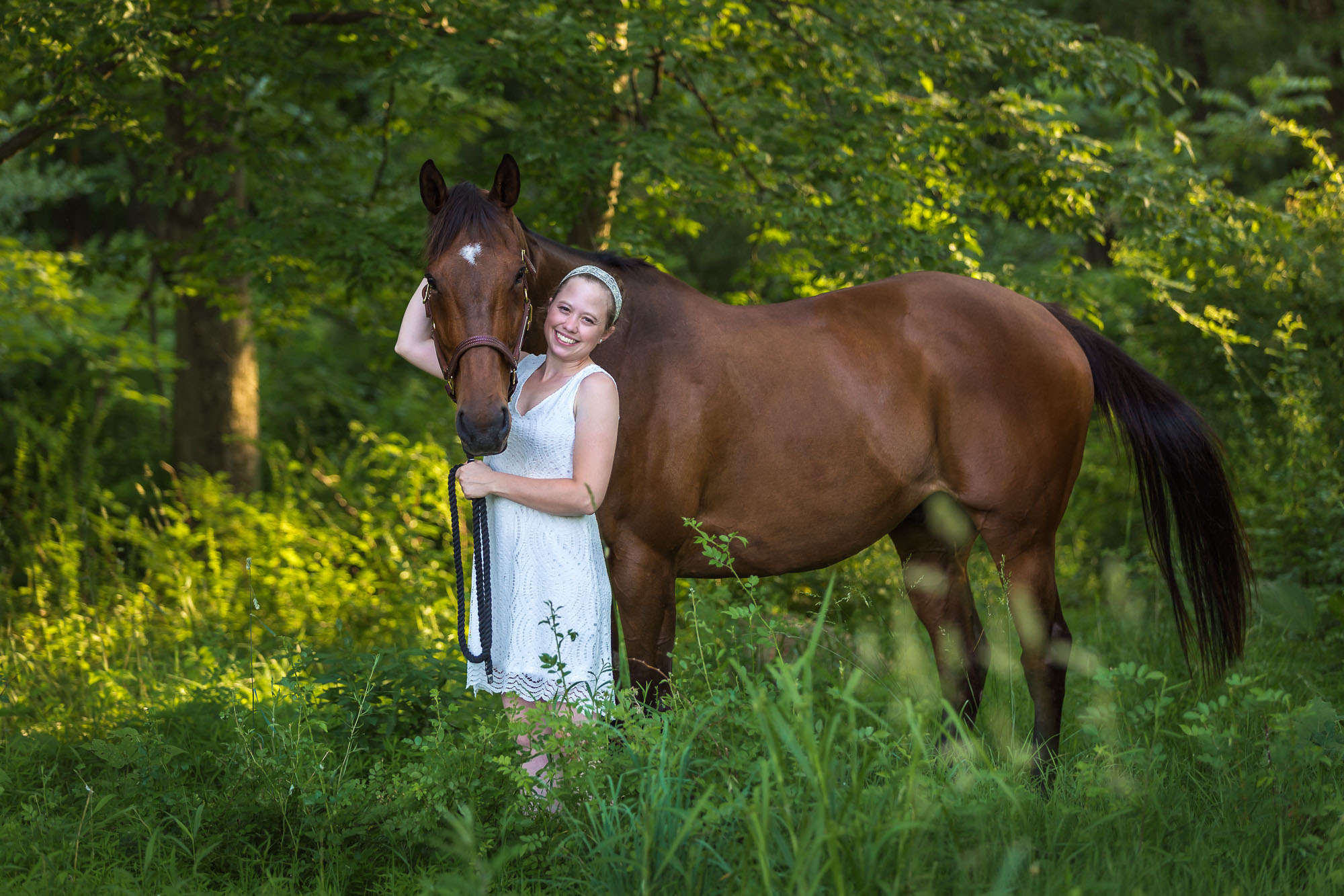 girl with arms wrapped around her horse in the woods