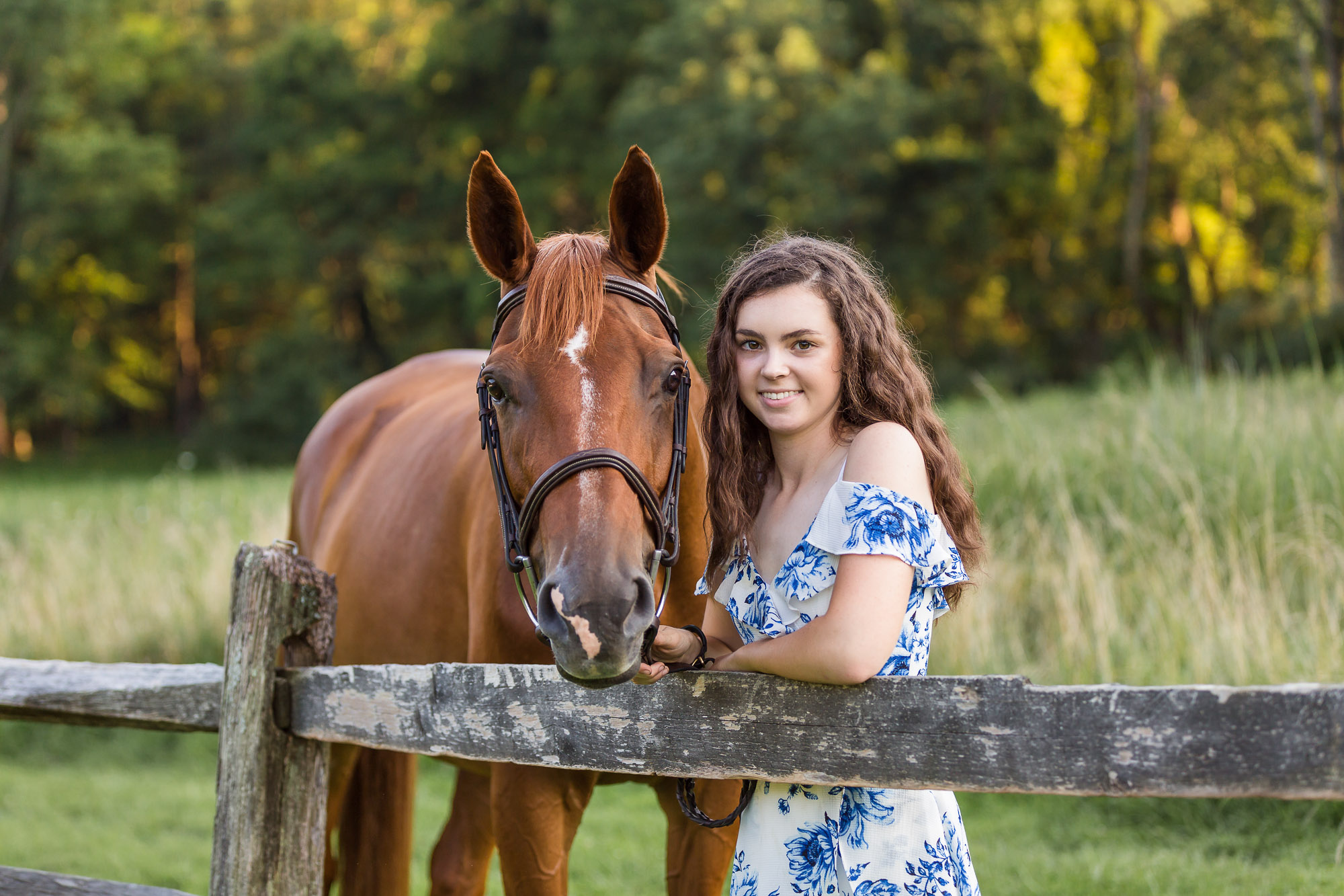 close up of young woman smiling with her chestnut horse