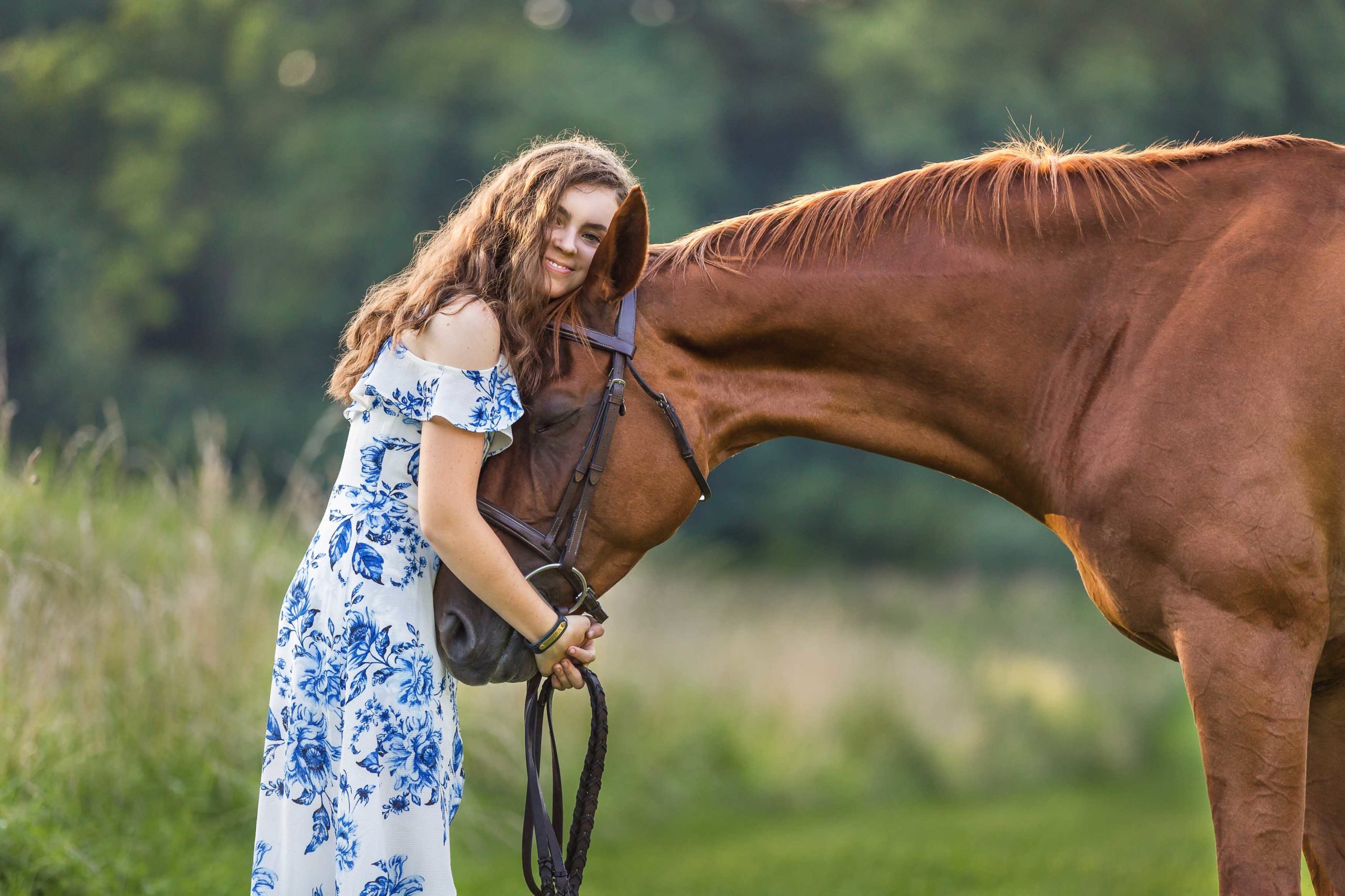 girl in blue flowered dress with horse
