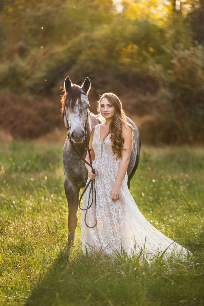 girl in white dress with dapple grey pony