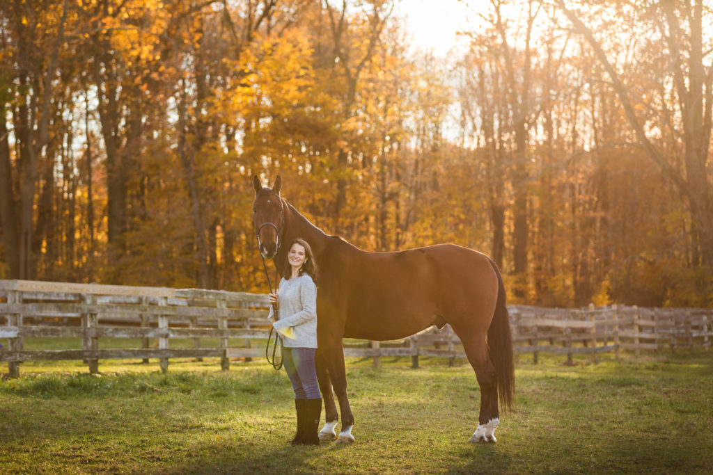 girl standing with horse in field at Hunters Crossing Farm