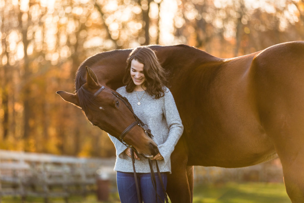 horse wrapped around girl in field
