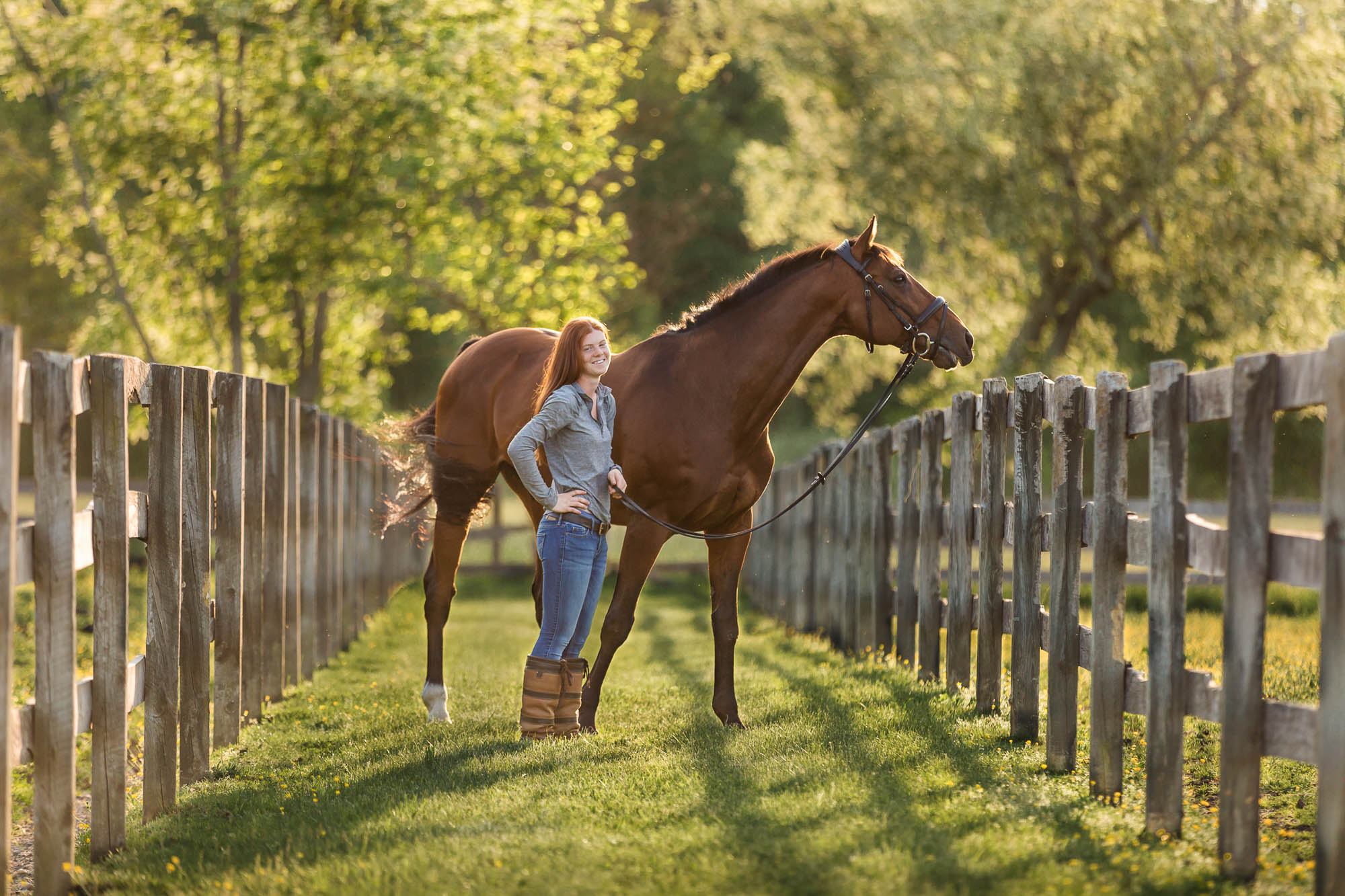 red haired girl holding her bay horse