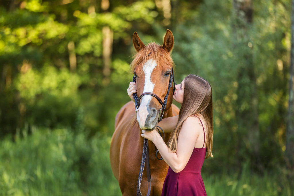 girl in burgundy dress looking at her mare at The Black Fox Farm