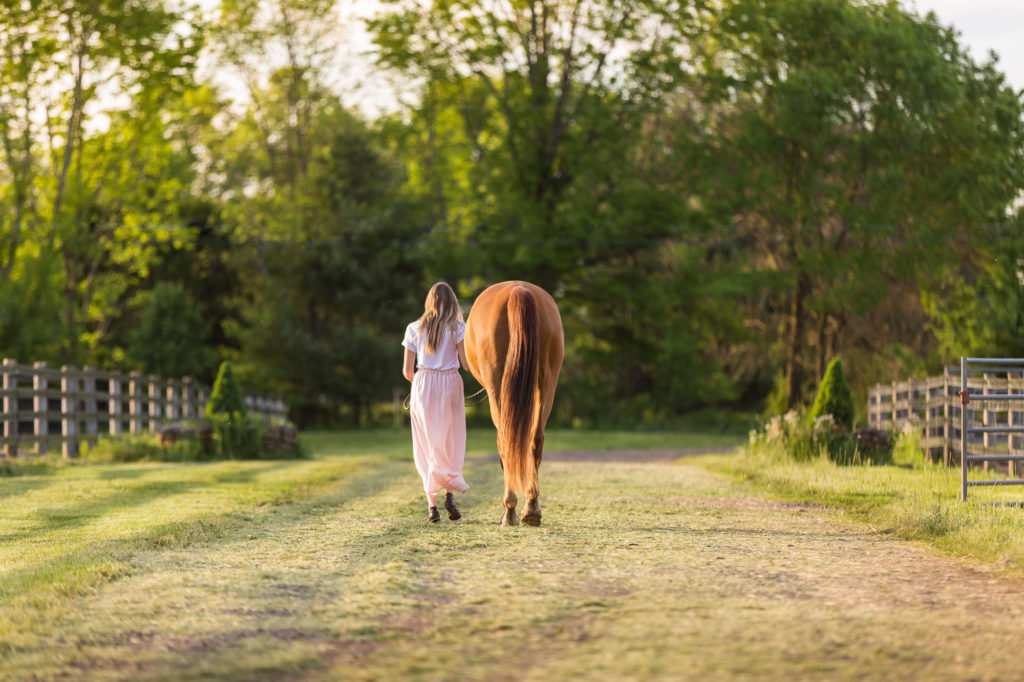 girl walking her mare down the driveway at Magnolia Creek Stables