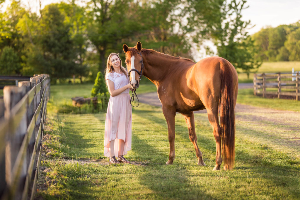 girl in pink skirt with her chestnut mare