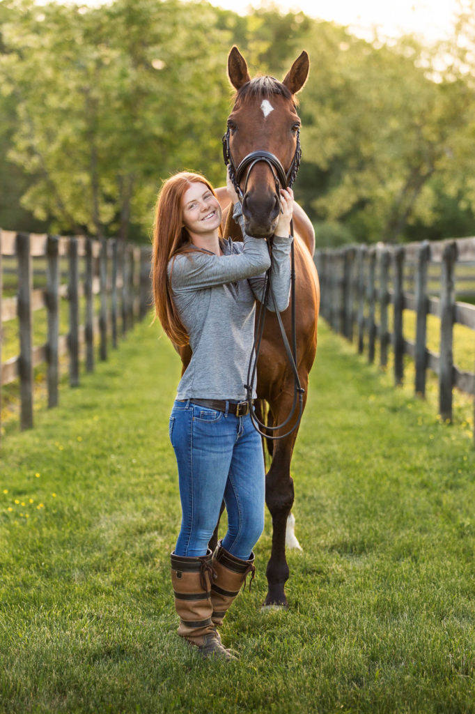 red headed girl in grey shirt with her bay horse at Golden Gait Farm
