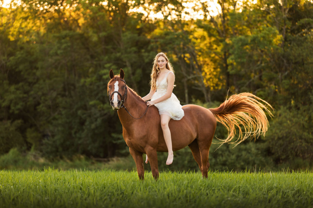 blond girl in white dress riding chestnut pony