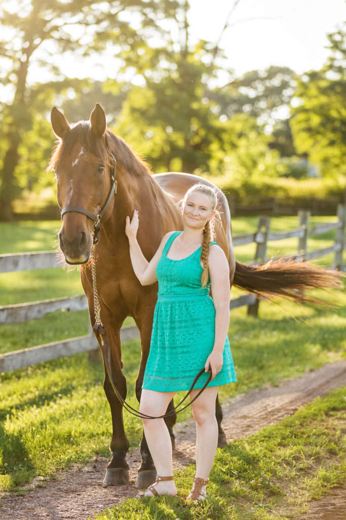 woman in turquoise dress standing with her bay horse at Robin Hill Farm