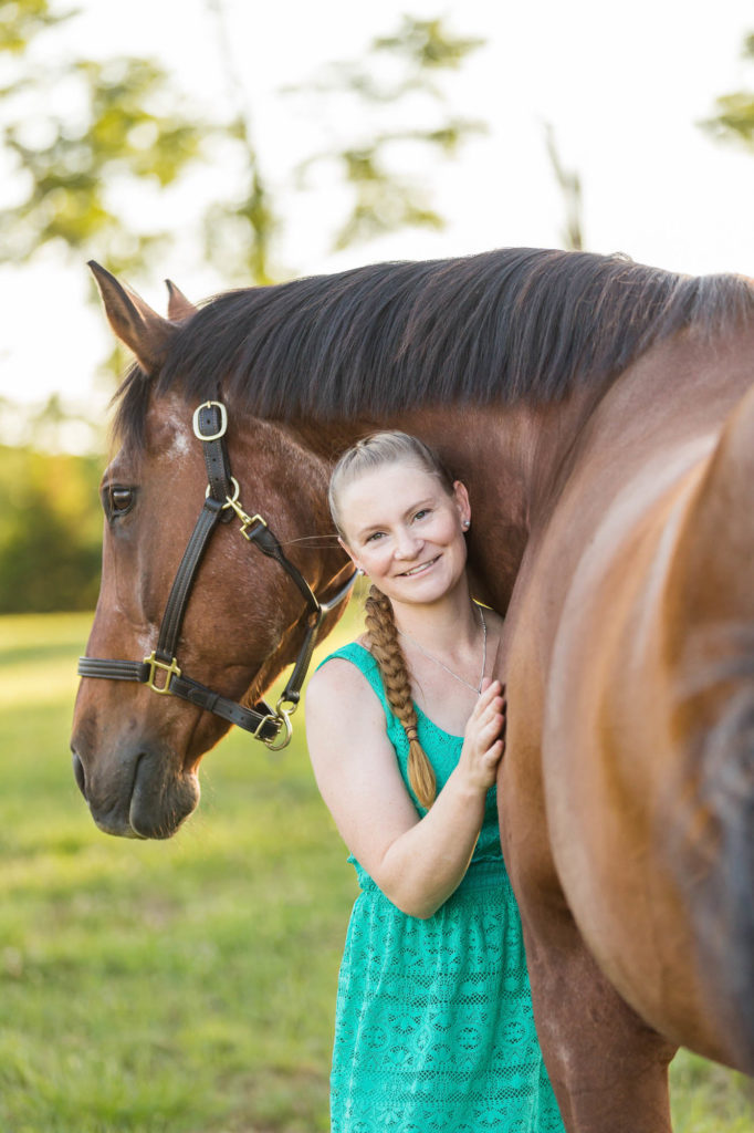 woman in turquoise dress hugging her bay gelding at Robin Hill Farm