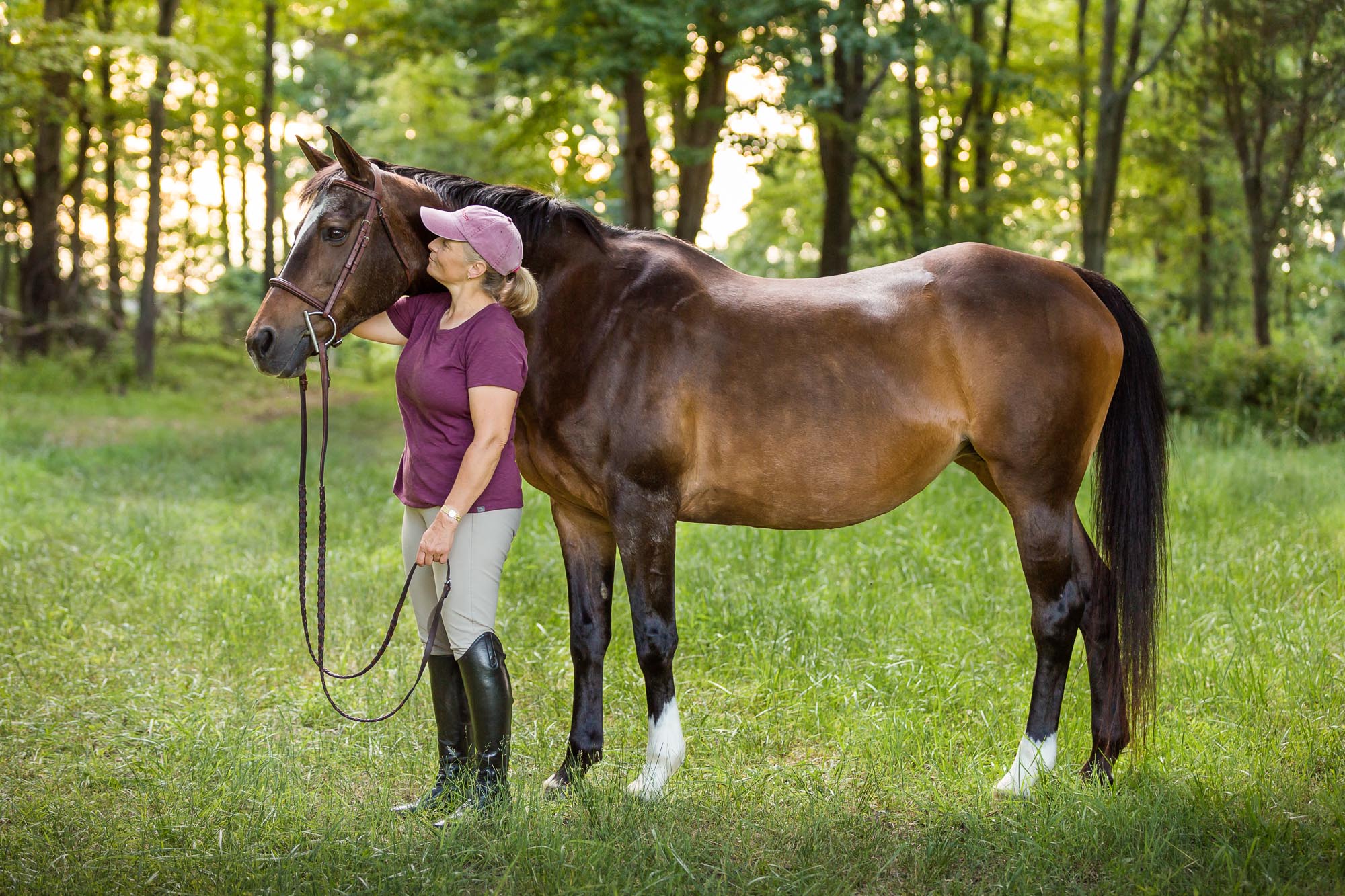woman in mauve top and hat standing with her mare at Ponyz on the Rockz