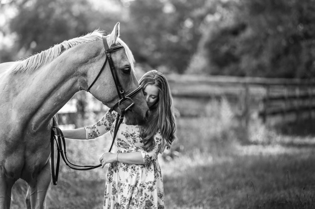 black and white image of girl kissing her horse at Tri-Brook Equestrian Center