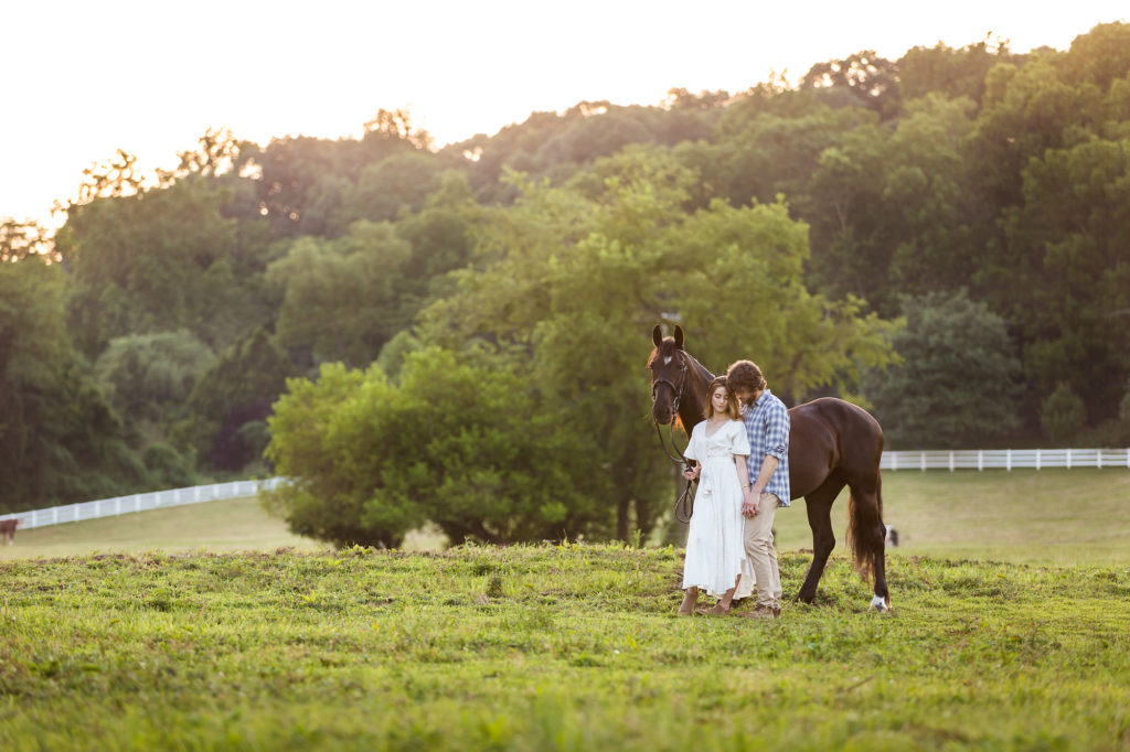 engaged couple with black horse at Great Scott Farm in Malvern PA