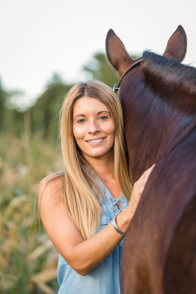 blond woman hugging her horse