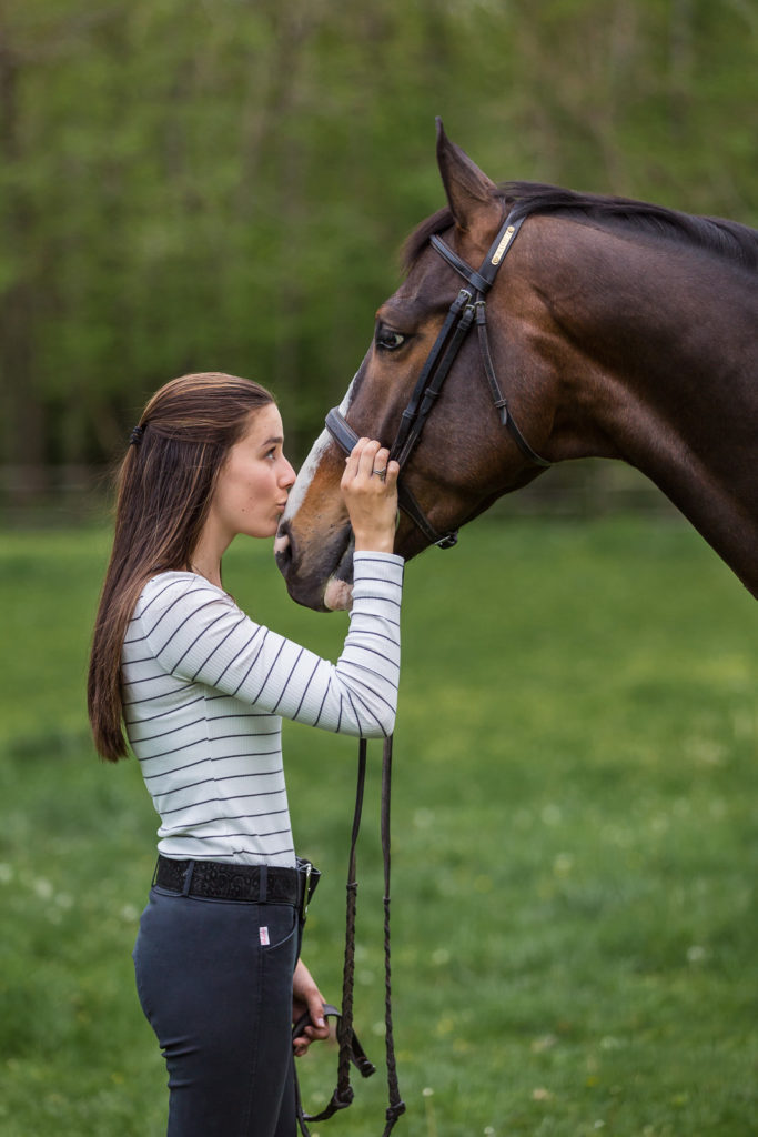 girl kissing her paint horse