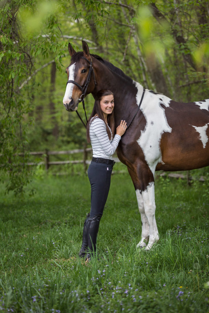 girl hugging her paint horse
