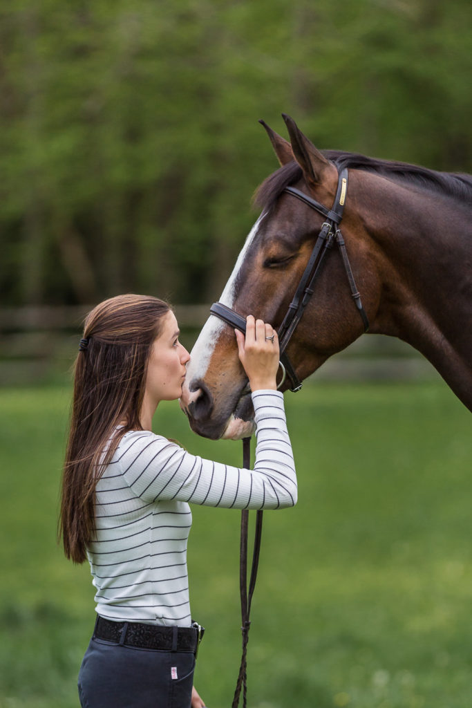 girl in striped top kissing horse