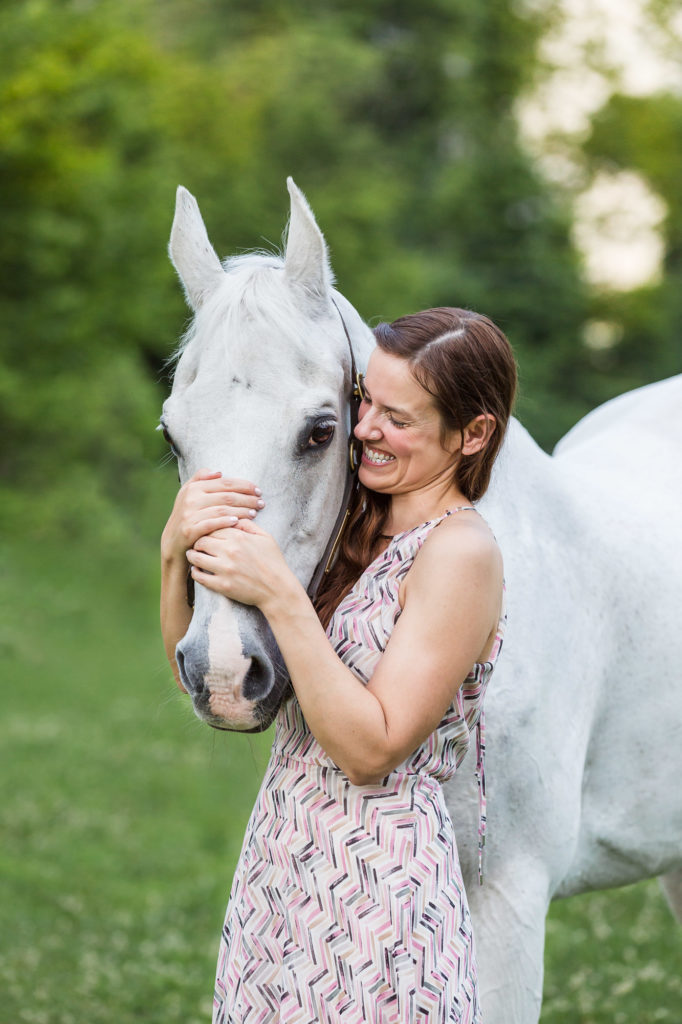 girl hugging her horse and laughing