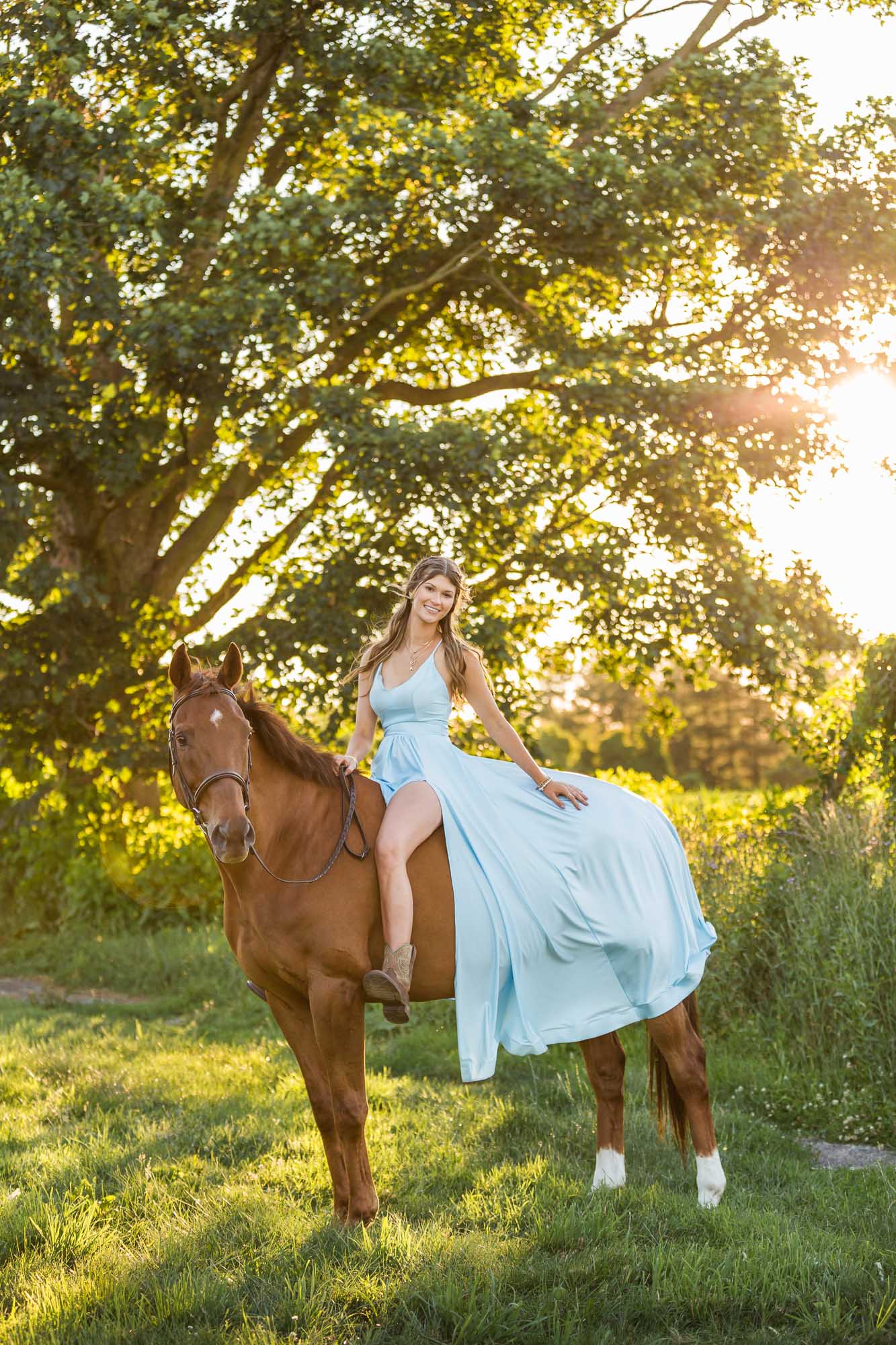 Alyssa poses in a blue dress on her horse Ben