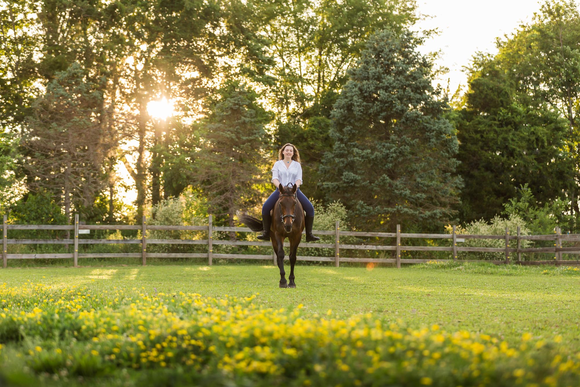 Kristi riding Kona in a field at Cavesson Corners